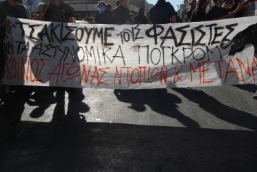 Uno striscione dei manifestanti: "Schiacciamo i fascisti e i pogrom della polizia. Greci e rifugiati lottano insieme". Foto dell'autore